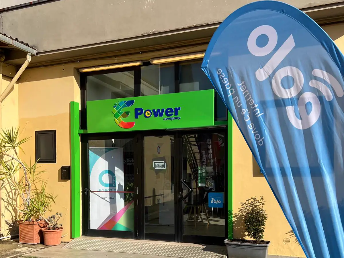Il negozio E-Power Company di Pieve al Toppo: insegna verde sopra la vetrina e le vele dei fornitori davanti all'ingresso